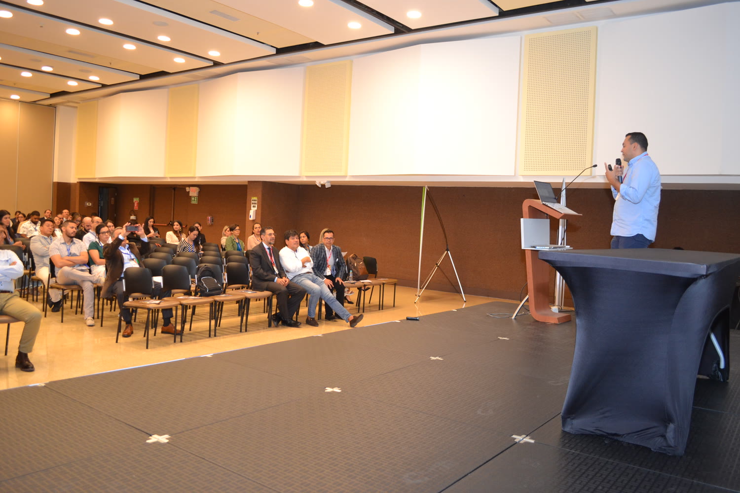 Conferencista en tarima ante el público en un evento ASAGIO